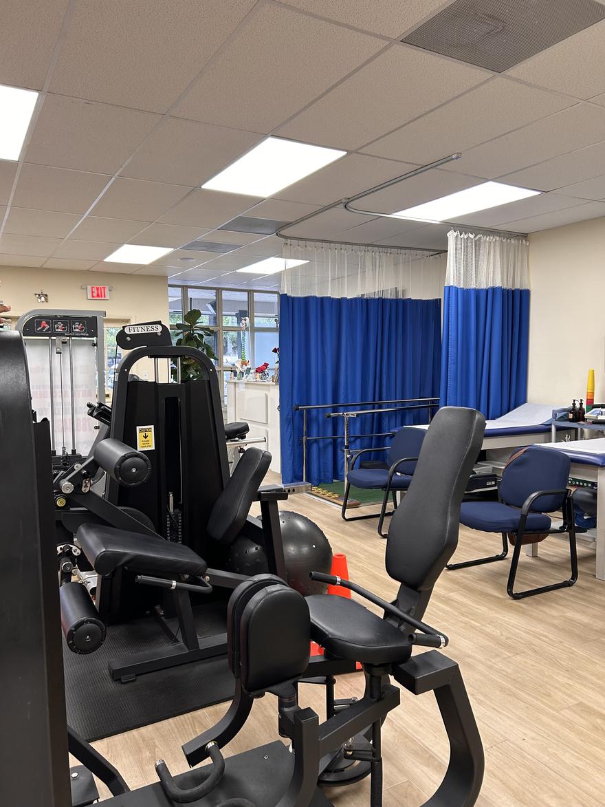 Therapy floor with parallel bars, treatment tables and privacy curtains